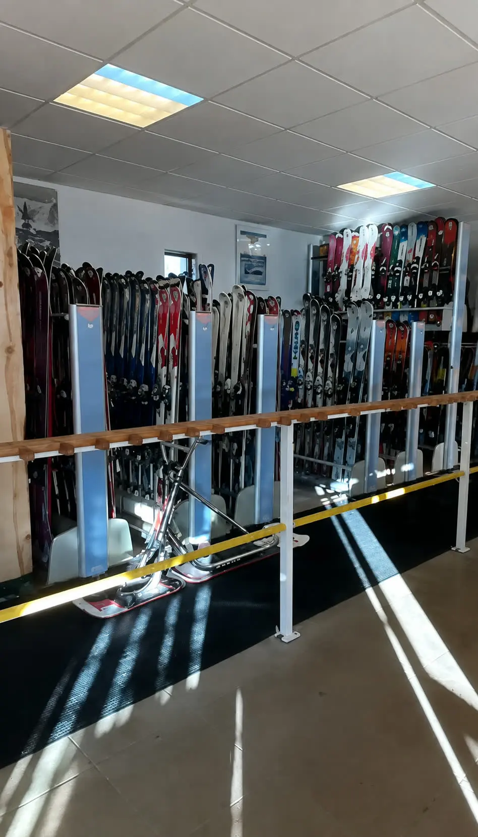 L'intérieur du magasin Bogho Sports : les skis de location alignés sur leurs racks